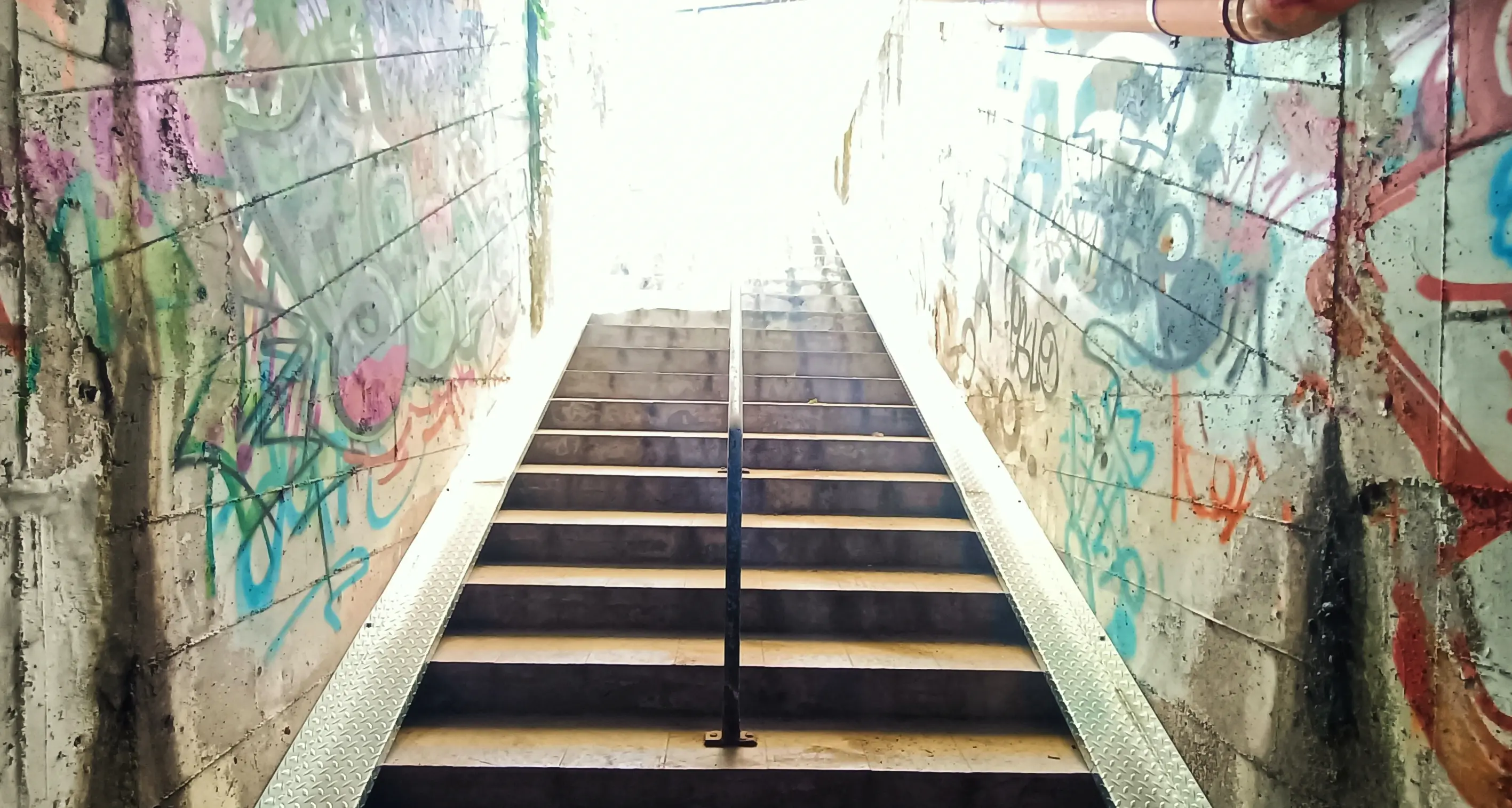 Il difficile trasporto di biciclette e rampichini lungo la scala del sottopasso tra le Slacche e la Mochena